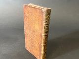 an old book sitting on top of a table next to a gray background