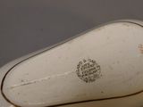 a close up of a white porcelain object with a brown stripe