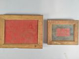 two framed paintings on a white wall one is red and the other is black
