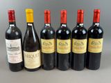 six bottles of wine are lined up in a row on a table
