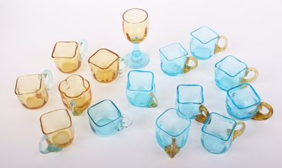 de nombreux verres et tasses de différentes couleurs posés sur une surface blanche