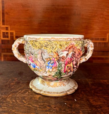 un vase muni d'une anse, posé sur une table dans une pièce