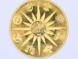 a gold coin with a design on it on a white surface