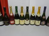 bottles of wine lined up on a table in front of a red curtain