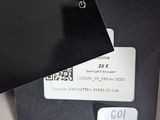 a black tag hanging from a black box on a white table