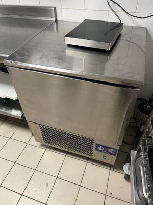 plan de travail en acier inoxydable dans une cuisine professionnelle équipée d'un micro-ondes