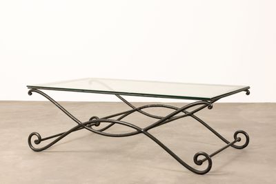 a glass coffee table with wrought iron legs and a glass top