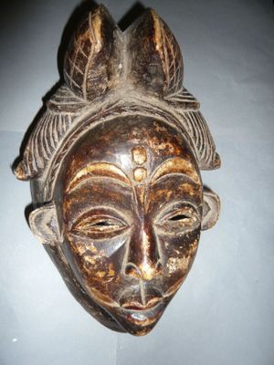 une image d'un masque en bois accroché au mur