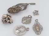 several silver jewelry items are displayed on a white surface
