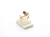 an image of a gold ring with a garnett on top of a stack of books