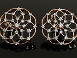a pair of diamond stud earrings on a black surface