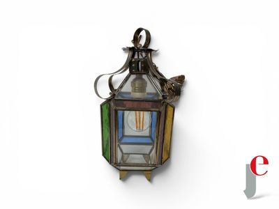 a small lantern hanging on the wall with a bird on it