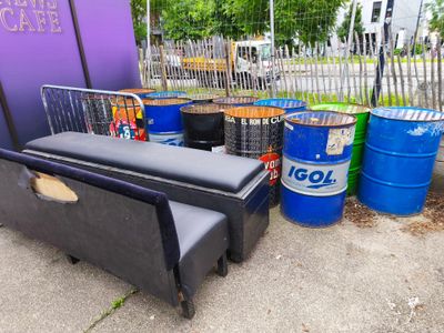 plusieurs tonneaux et un canapé posés au bord de la route