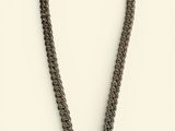 a black necklace with a spiral design on a white background