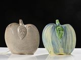 two apple shaped vases sitting next to each other on a table