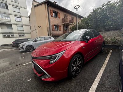 a red car parked in a parking lot next to a building