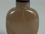 a brown glass bottle with a gold lid on a table