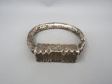 gros plan d'un bracelet en argent sur une surface blanche