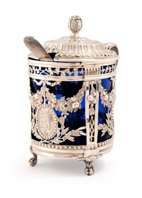 un vieux bocal en argent et en verre bleu contenant une cuillère