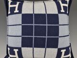 a blue and white plaid pillow with the letter h on it