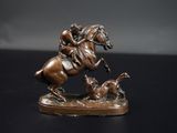 statue en bronze représentant un homme à cheval, avec un chien qui court derrière lui