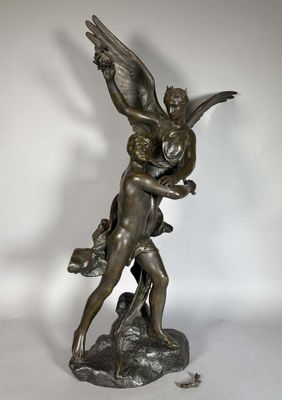 une statue antique en bronze représentant un ange tenant un enfant dans ses bras