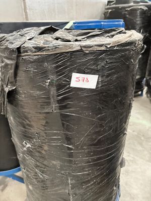 many black plastic barrels sitting in a warehouse