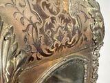 a silver clock that is on display on a table