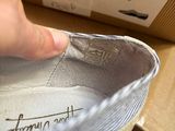 a hand that is holding a shoe that is on a box