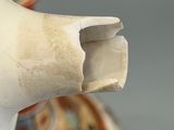 a close up of a vase with a broken handle