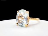 Gros plan sur une bague en or ornée d'une topaze bleue