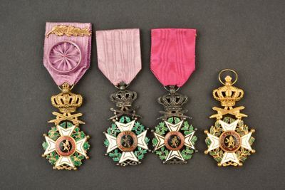 quatre médailles sont exposées sur une table, ornées d'un ruban rose