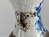 a white vase with a blue and white design on it
