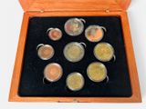 a wooden box with six different coins in it