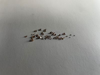 a lot of tiny pieces of metal on a white surface