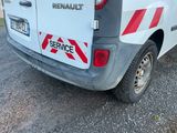 une camionnette blanche avec une bande rouge et blanche à l'arrière