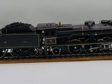 un train miniature dans une vitrine, posé sur une surface blanche