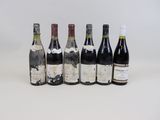 six bouteilles de vin sont alignées sur une surface blanche