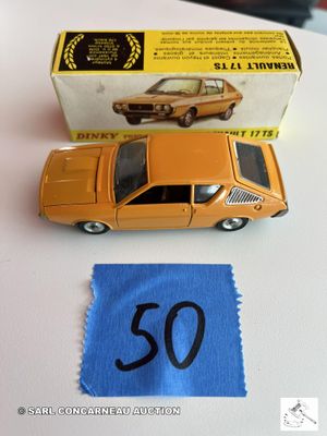une petite voiture miniature posée à côté d'un morceau de tissu sur une table