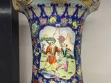 a vase with a painting on it sitting on a shelf