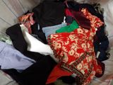 a pile of clothes sitting in a basket on a bed