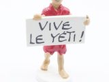 a small figurine of a man holding a sign