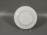 a white plate on a stand on a gray surface
