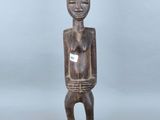 une statue en bois d'un homme avec un chapeau sur la tête