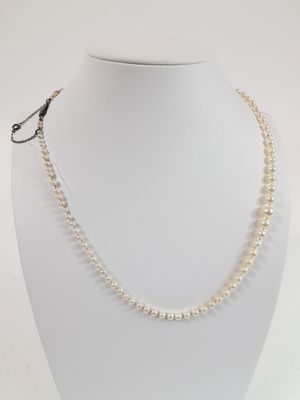 a close up of a white necklace on a mannequin