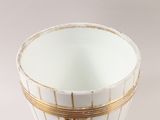 a white cup with a gold rim on a white table