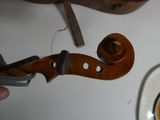 a violin that is being worked on with a pair of pliers