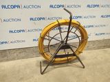 a large yellow hose on a stand in front of a wall