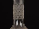 a clear glass bottle with an intricate design on it