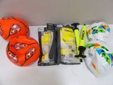 several soccer balls, gloves, and a bat are sitting on a table